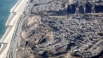 An aerial view of fire trucks, utility, and other vehicles parked along Pacific Coast Highway on January 13, 2025 near homes destroyed in the Palisades Fire as wildfires cause damage and loss through the LA region in Pacific Palisades, California. Multiple wildfires fueled by intense Santa Ana Winds continue to burn across Los Angeles County, with some containment achieved. Photo: Mario Tama/Getty Images.